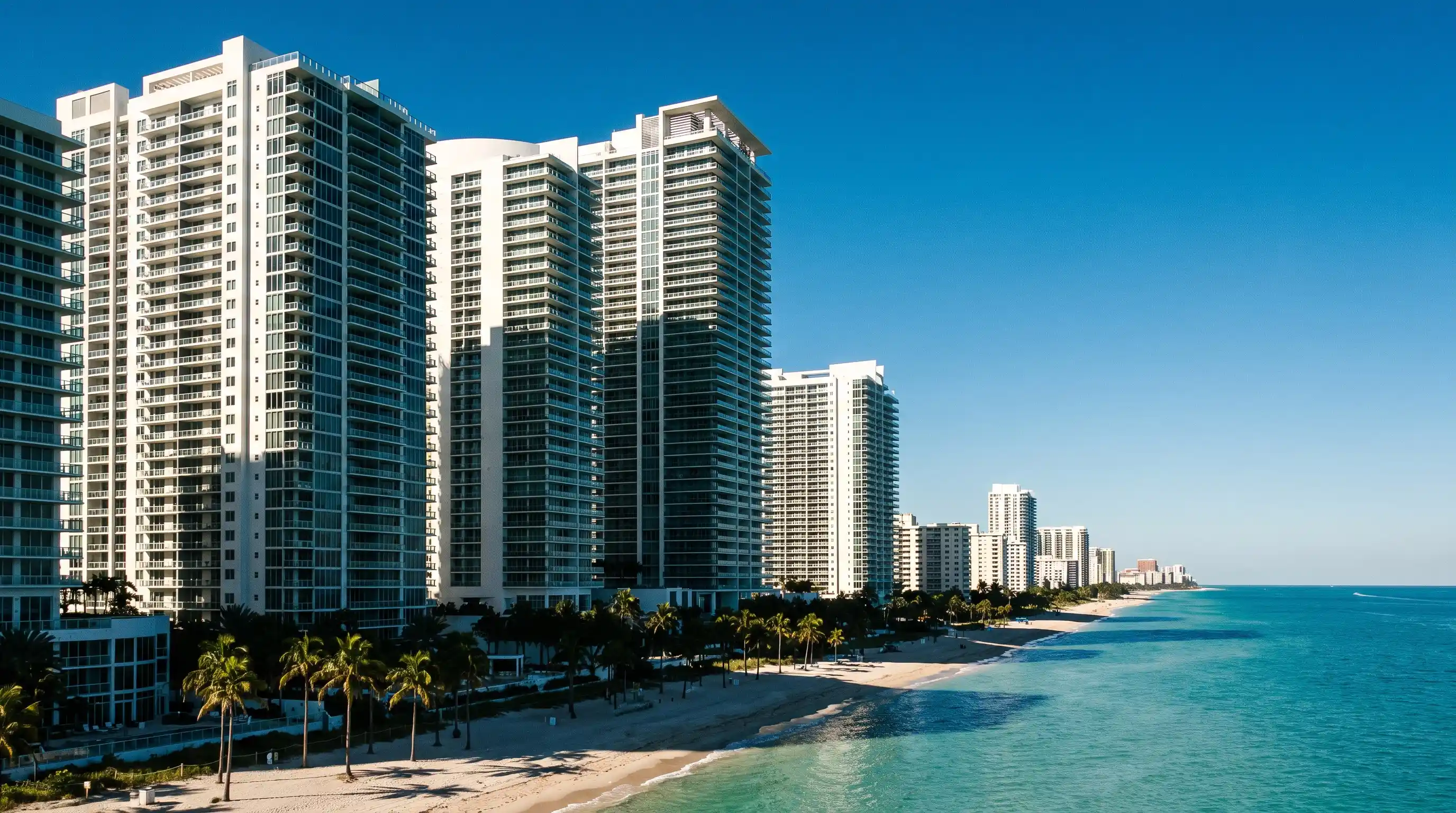 High-rise condominium towers along a sunny South Florida coastline